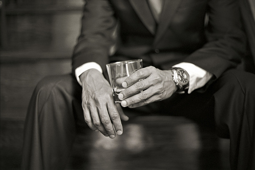man in suit holding a whiskey glass